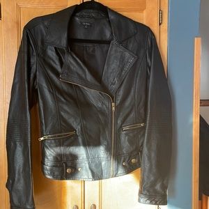 Faux Leather jacket with offset front zip. Zip pockets and adjustable waist.